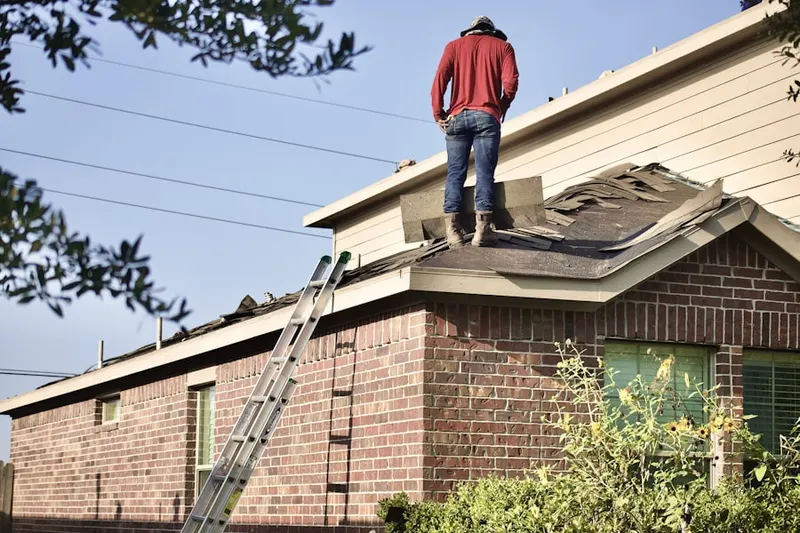 Professional roofer working on a residential roof in Byram Cove